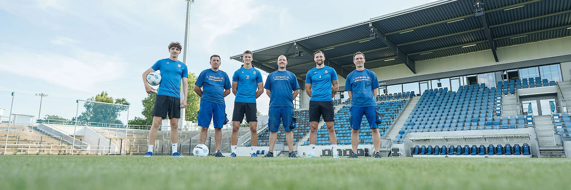 Das Hofmann-Team steht auf dem Fußballplatz - warten darauf Sie zu begrüßen.