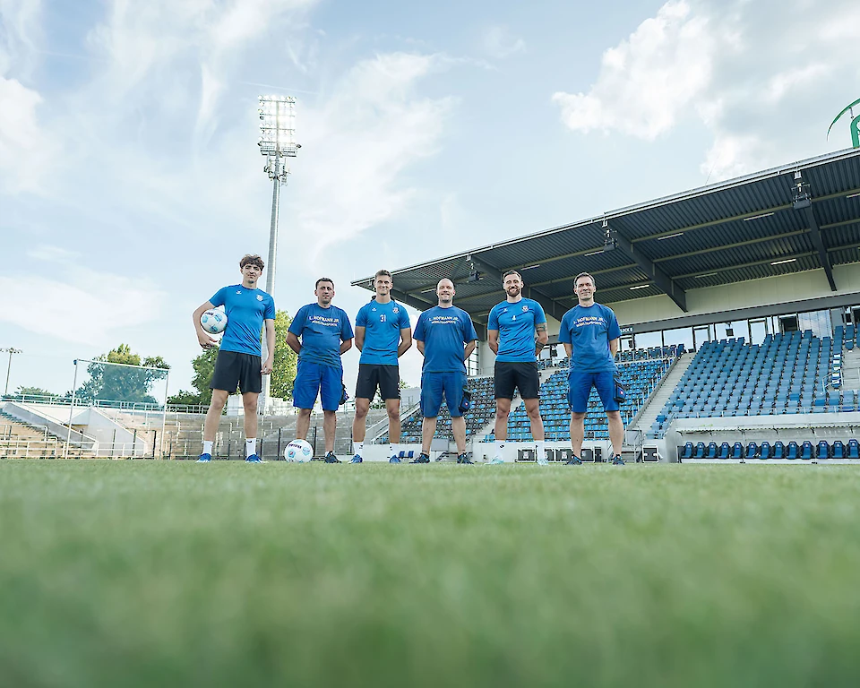 Das Hofmann-Team steht auf dem Fußballplatz - warten darauf Sie zu begrüßen.