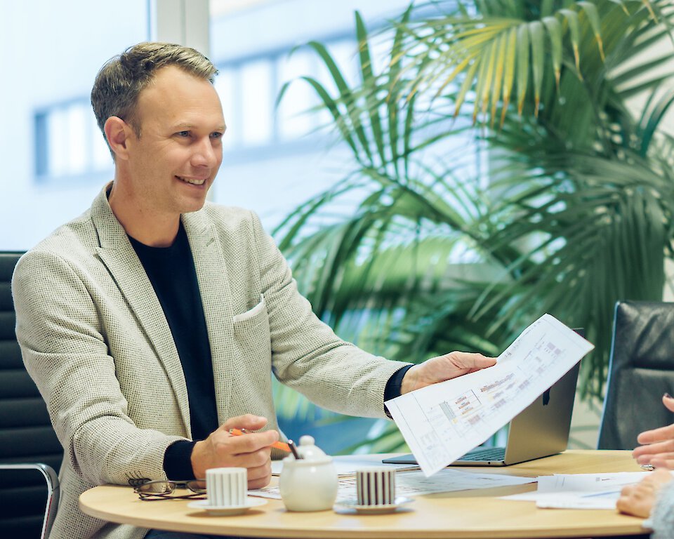 Beratung zum Umzugsmanagement: Hofmann-Mitarbeiter bespricht Dokumente mit einer Kundin in einem modernen, hellen Büro.