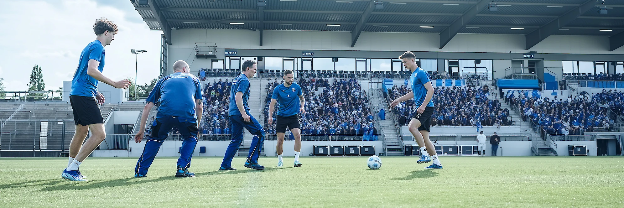 Hofmann-Team spielt in einem Stadion zusammen Fußball.