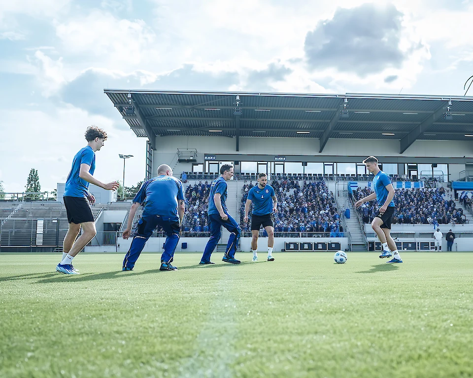 Hofmann-Team spielt in einem Stadion zusammen Fußball.